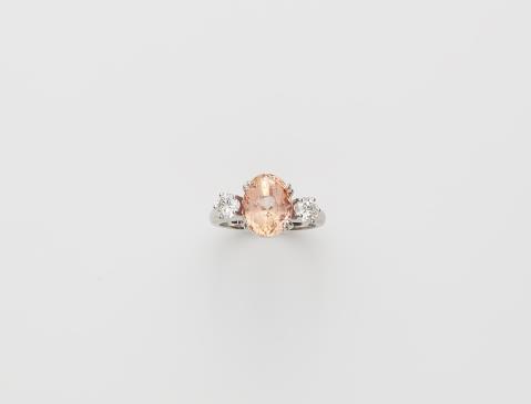 René Kern - A German 18k white gold diamond and pink-orange sapphire ring.