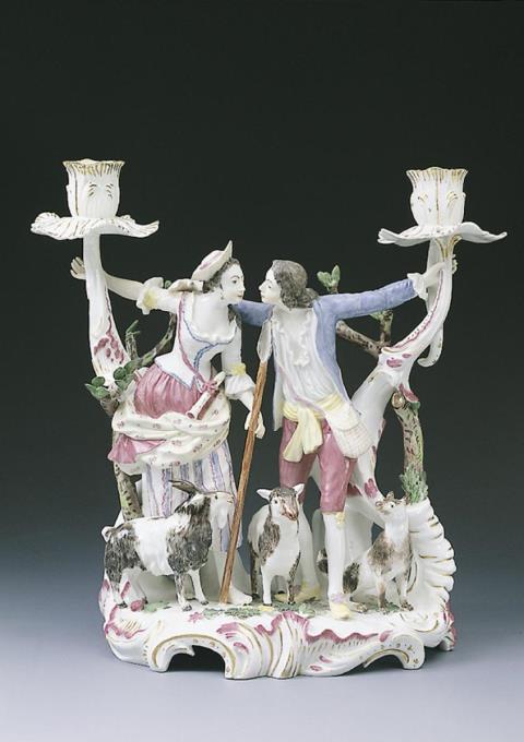 A Höchst porcelain candlestick with kissing figures