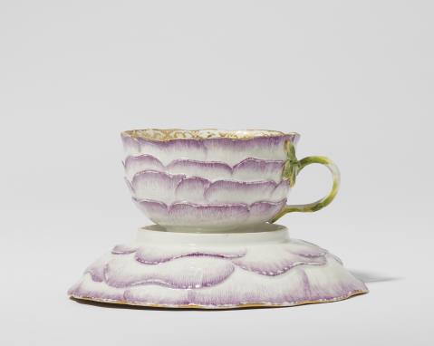 A Meissen porcelain cup and saucer with rose tendril reliefs